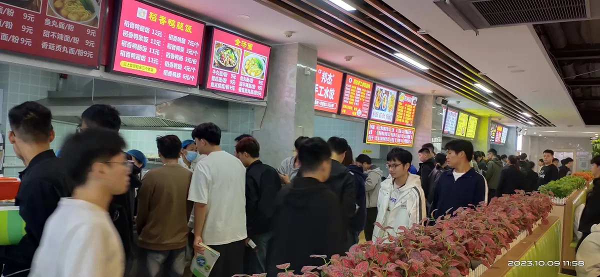 食堂美食城档口前人群排队选餐